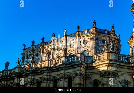 Great close‑up view of the upper section of the Hofkirche’s two‑tier processional gallery, its sculpted balustrades and stone saints glowing in the... Stock Photo