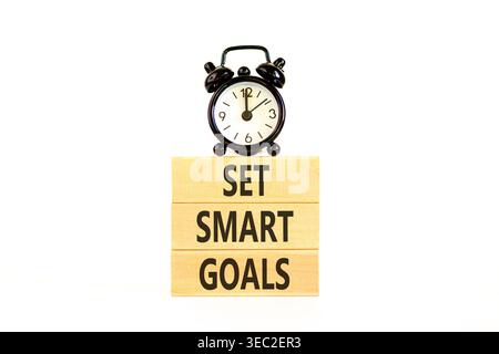 Set smart goals words symbol. Concept words Set smart goals on beautiful wooden blocks. Beautiful white background. Black alarm clock. Business and se Stock Photo