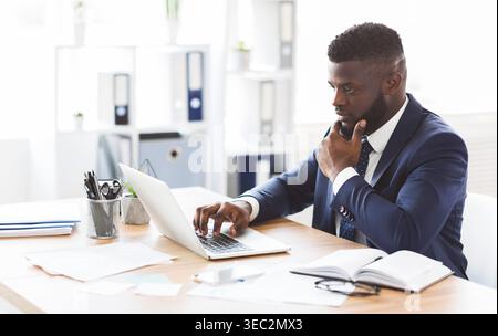 Young african american entrepreneur studying competitors online Stock Photo