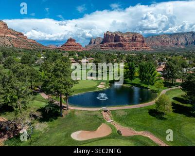 Aerial view of golf course with pond and fountain in Sedona Arizona with red rock formations including Bell Rock in background Stock Photo