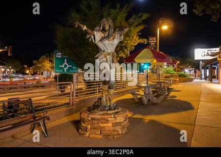 Bird Woman statue in Sedona Arizona at night along Highway 89A with street lights, shops and urban scene Stock Photo