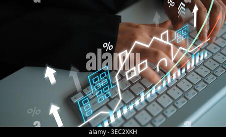 Hands Typing on Keyboard with Financial Growth Concept and Real Estate Elements Representing Market Trends and Investment Opportunities in Digital Age Stock Photo