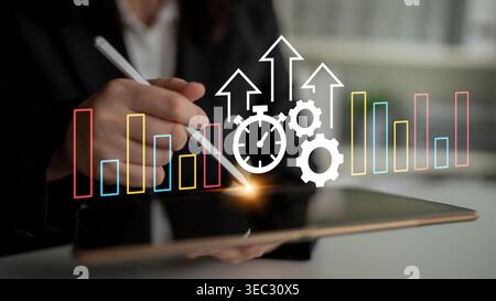 Business Analytics and Time Management Concept with Digital Tablet, Graphs, and Progress Indicators in Office Environment Ledger. Stock Photo