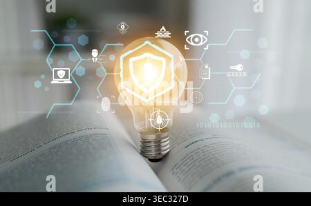 Light bulb with glowing shield symbol on open book background, representing knowledge, security, and innovative ideas in technology and education Stock Photo