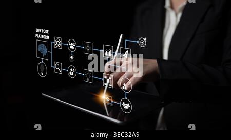 Business Professional Interacting with Low Code Platform on Tablet in Dark Environment, Showcasing Modern Technology and Digital Innovation Strategies Stock Photo
