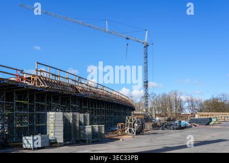 Tower crane and bridge construction site with scaffolding structure under clear blue sky view Stock Photo