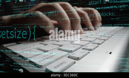 A detailed close-up image of hands typing on a computer keyboard, surrounded by flowing lines of code, representing modern programming and digital Stock Photo