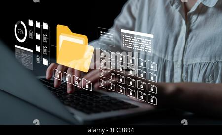 Engaging image of a user typing on a laptop surrounded by digital graphics representing files and data security, showcasing modern technology and data Stock Photo