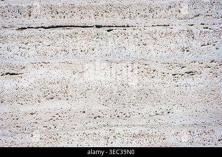 Light beige travertine stone texture with natural porous pattern and horizontal lines, detailed background. Stock Photo