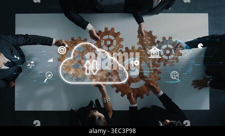 A dynamic team collaborates over a table with gears representing workflow, showcasing the integration of cloud technology and innovative strategies Stock Photo