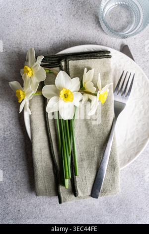 Overhead view of a spring place setting with fresh daffodils on a table Stock Photo