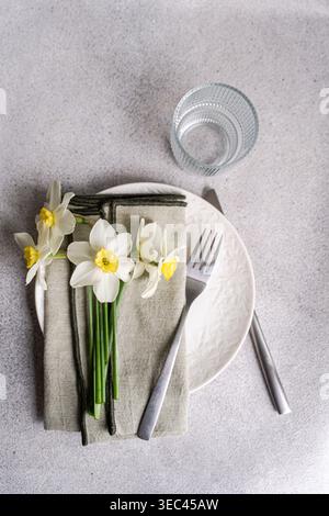 Overhead view of a spring place setting with fresh daffodils on a table Stock Photo