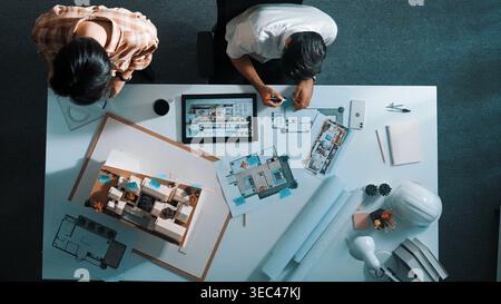 Top view of business man working together to design house. Aerial view of architect engineer looking at tablet display blueprint. Aerial view of Stock Photo