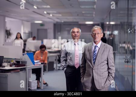 Middle Eastern business leaders walking through modern open-plan office during a professional meeting Stock Photo