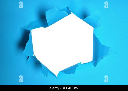 Torn Blue Paper Background with a Hole Featuring Blank White Space for Text or Images Stock Photo