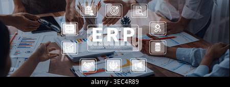 A business team collaborates in a modern office, surrounded by reports and digital icons representing ERP concepts for effective project planning and Stock Photo