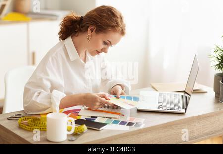 Designer atelier. Dressmaker choosing color samples for new collection Stock Photo