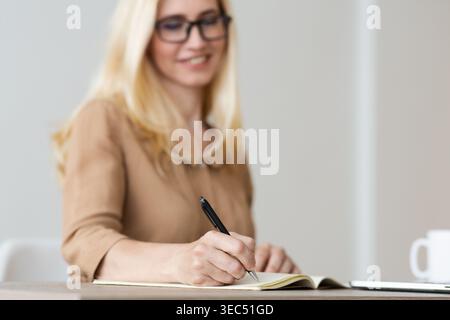 Mature Freelancer Writing Down Plans Project Into Notebook Stock Photo