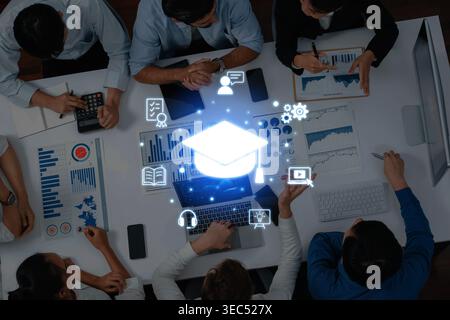 A group of individuals engage in a collaborative learning environment, utilizing digital tools and educational icons to enhance their understanding Stock Photo