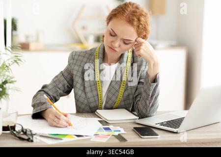 Creative Designer Working on Fashion Project With Sketches and Color Palettes in Office Stock Photo