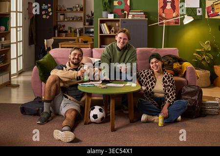 Portrait of diverse students relaxing, checking bills, sharing drinks together in apartment. Useful for youth lifestyle, college housing, friendship, student budget concepts Stock Photo