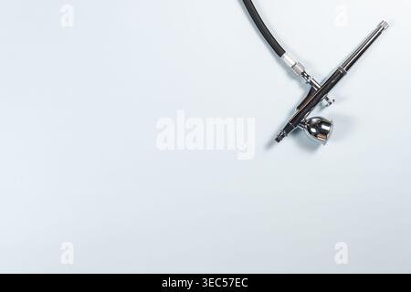 Top Down View of Airbrush on Clean Minimal Surface – Precision Painting Tool Stock Photo