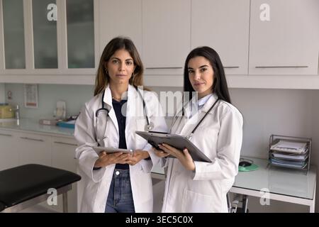 Portrait of two serious Hispanic women healthcare workers colleagues Stock Photo