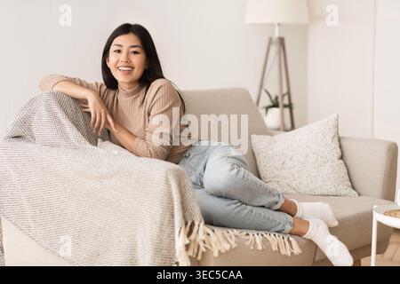 Happy Teen Girl Resting on Comfortable Sofa Stock Photo