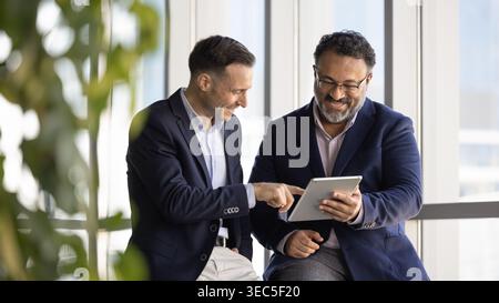 Two smiling businessmen reviewing information on digital tablet Stock Photo