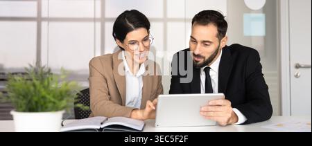 Colleagues collaborating on strategy using digital tablet in office Stock Photo