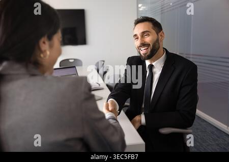 Businessman shaking hands with colleague finalizing successful teamwork in office Stock Photo