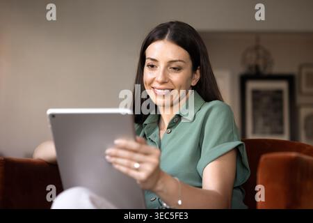 Smiling woman using digital tablet at home Stock Photo