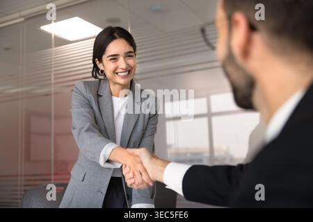 Female applicant and HR manager shaking hands in meeting room Stock Photo