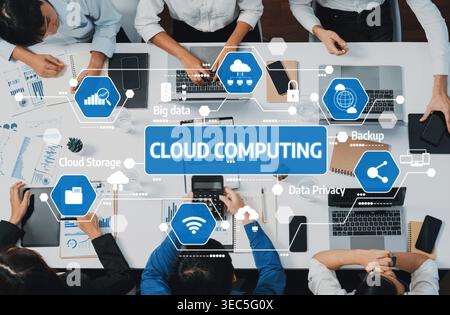 A diverse team collaborates using cloud computing concepts, focusing on data storage, privacy, and backup solutions in a modern office environment Stock Photo