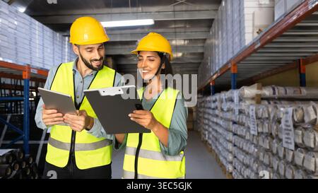 Two warehouse workers collaborating on inventory control Stock Photo