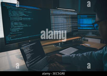 Developing programmer Website design at a multi monitor workstation with laptop and screens displaying scripts, showing web development, coding, softw Stock Photo