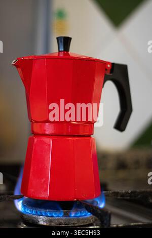 Italian moka coffee maker on gas stove with blue flame, home coffee preparation Stock Photo