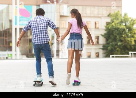 Young Couple Enjoying a Fun Day Skating While Holding Hands in an Urban Setting Stock Photo