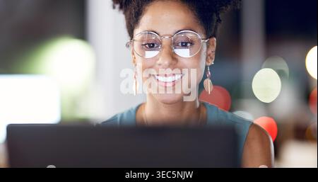 Night, woman and smile in office with laptop, glasses or check deadline for digital marketing project. Late, bokeh and person in business with Stock Photo