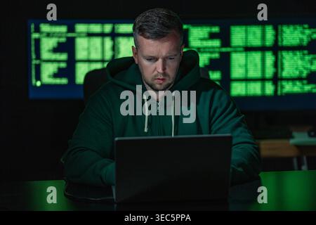 Hacker works on programming and coding. Hacker analyzes digital system vulnerabilities. Hacker monitors secure network infrastructure. Hacker attempts Stock Photo