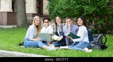 Happy college students resting in campus, smiling to camera Stock Photo