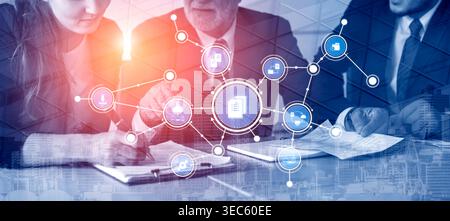 A business team collaborates in a modern office setting, focusing on digital connections and documents. Icons represent communication and strategy for Stock Photo