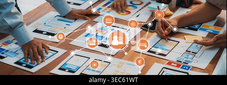 Engaging scene of a collaborative workspace featuring diverse hands working together on digital interfaces, infographics, and project planning strateg Stock Photo