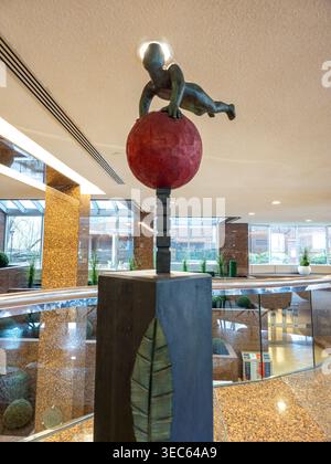 Contemporary art installation blending human form with geometric structure in a modern architectural space. Stock Photo