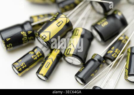 Group of electrolytic capacitors on white background. Electronic components for circuit board repair and DIY electronics. Macro shot of small black Stock Photo