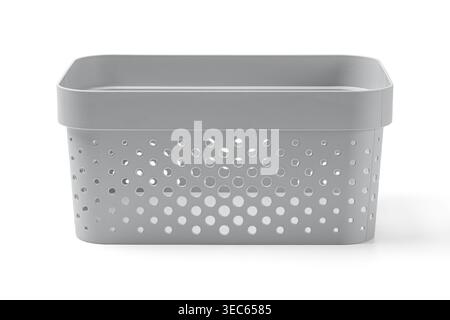 Stack of grey plastic storage baskets with hole pattern on white background. Minimalist home organization and decluttering concept. Studio shot of lau Stock Photo