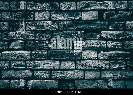 Old shabby painted brick wall. Aged dark brickwork texture. Gloomy grunge background Stock Photo