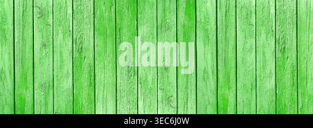 Old wooden boards with weathered bright green grass color paint wide texture. Shabby wood plank rustic vintage background Stock Photo