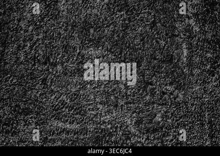 Cracked black textured plaster wall. Dark abstract background Stock Photo