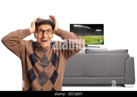 Surprised elderly man holding his head and watching a football match isolated on white background Stock Photo